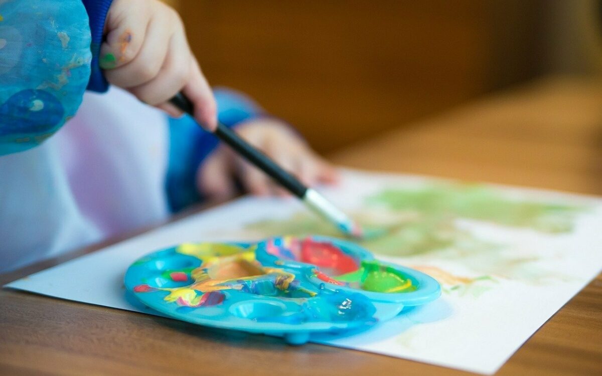 Ein Kind malt mit Wasserfarbe Palette zu sehen Ein Kind malt mit Wasserfarbe Palette zu sehen
